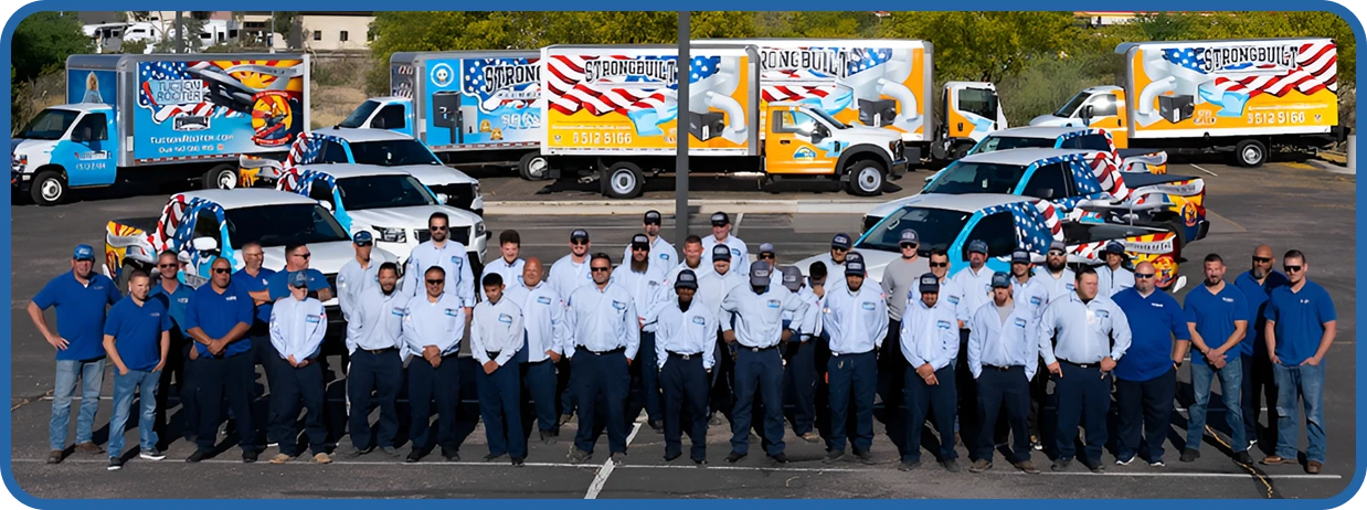 A group of people in blue uniforms stand in front of several decorated trucks in a parking lot.